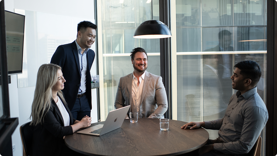 4 colleagues talking and smiling