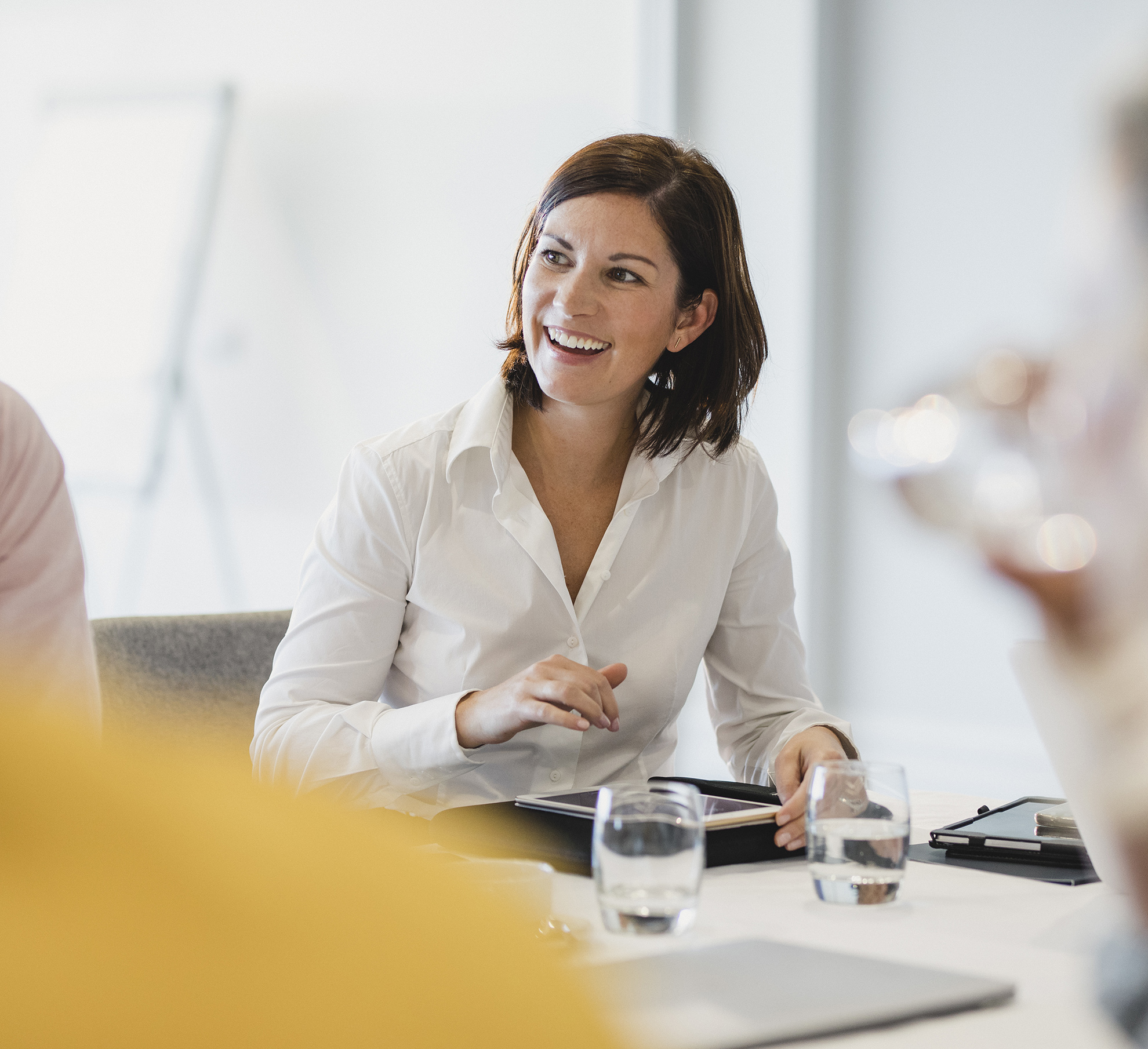 Cheerful mid adult woman smiling at business meeting