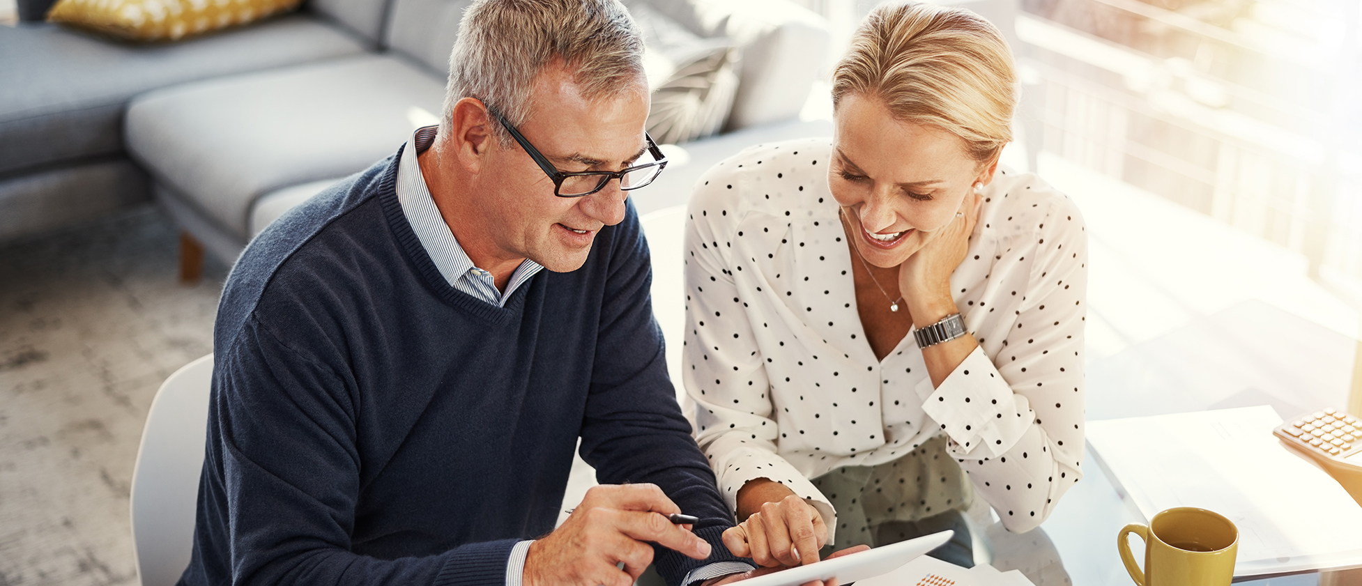 Shot of a mature couple using a digital tablet while going through paperwork at home