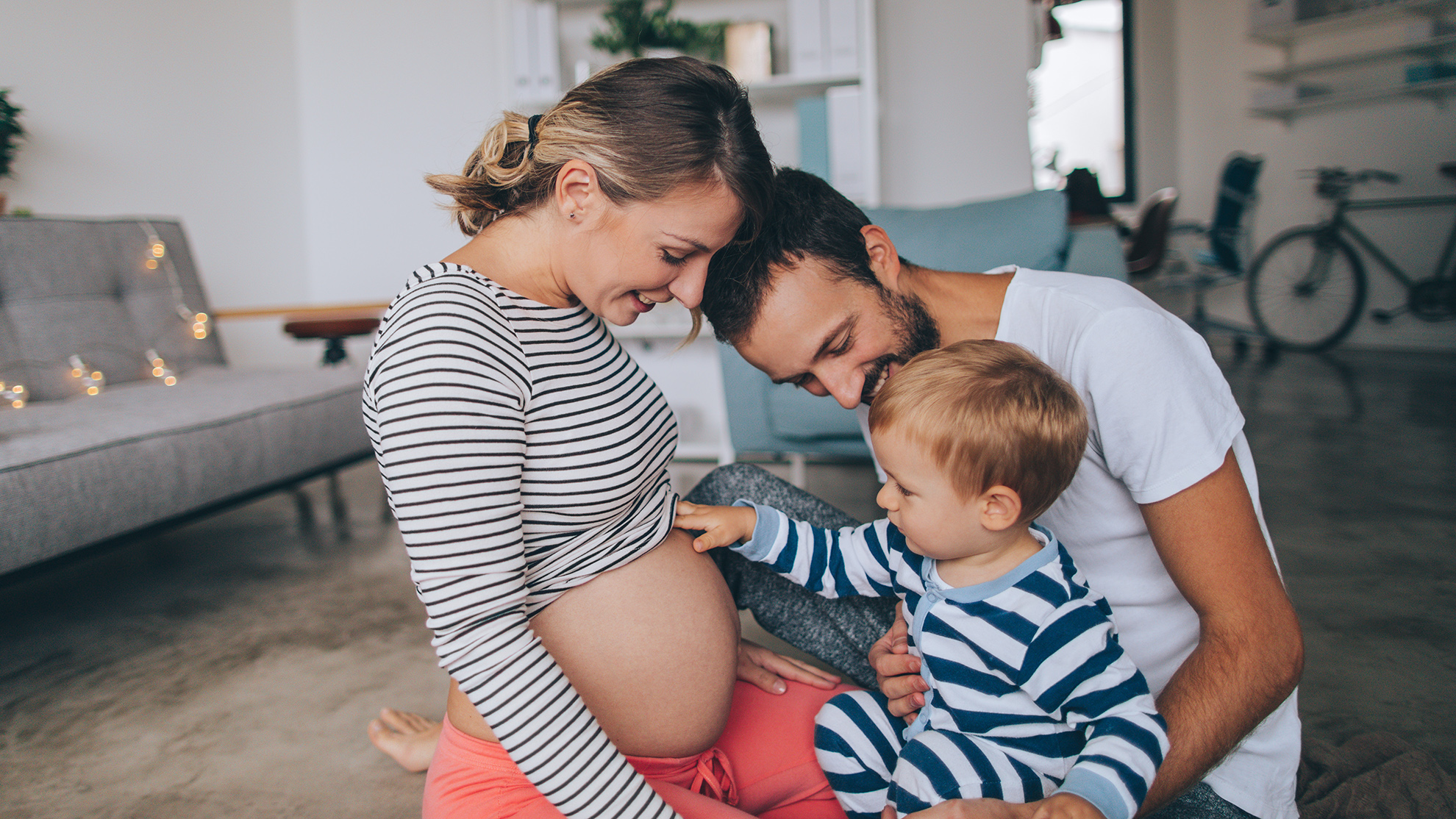 Photo of a little boy being curious about his mother's growing belly